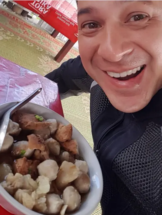 "Hepi face..Wong enake makan di kampung toh? Satu mangkok pul bakso, tahu + bonus tetelan/gajih, cuma 10rb...warbiasa.. Daerah Tawangmangu otw ke Kediri dari Solo.." aku bintang film Langit Biru itu. (Instagram/ariwibowo_official)