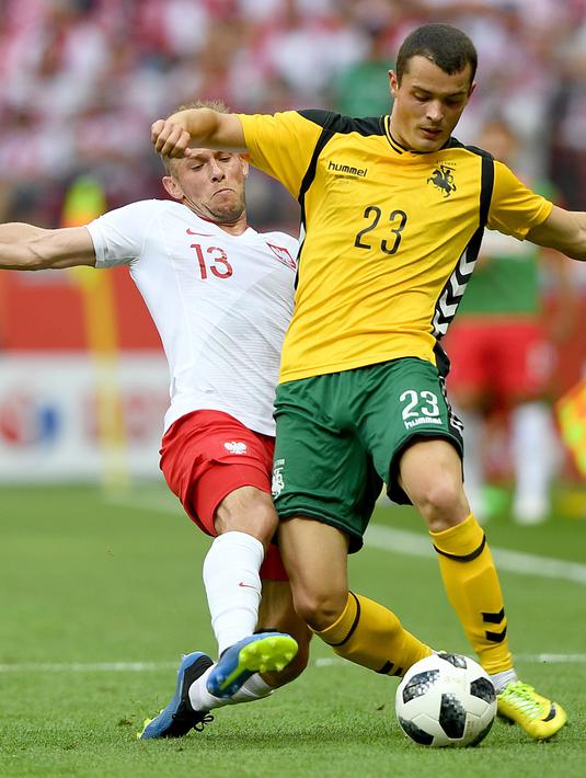 Pemain Polandia, Maciej Rybus (kiri) berusaha merebut bola dari kaki pemain Lituania, Rolandas Baravykas pada laga uji coba di Stadion Narodowy, Warsaw, Polandia, (12/6/2018). Polandia menang 4-0. (AFP/Janek Skarzynski)