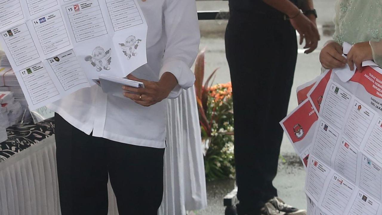 Jokowi sempat membuka lembaran surat suara sebelum menuju ke bilik pencoblosan. Foto: merdeka.com / Arie Basuki