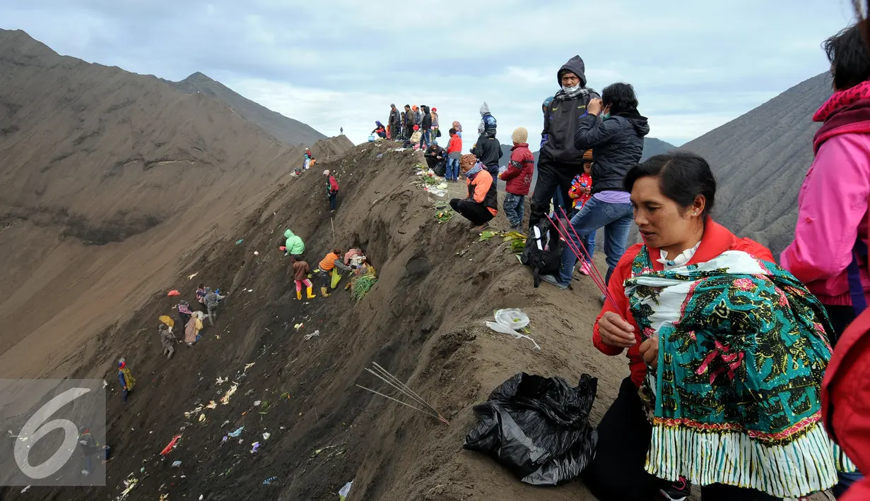 Warga suku Tengger membakar dupa di bibir Kawah Gunung Bromo saat upacara Kasada, Probolinggo, Kamis (21/6). Meski Gunung Bromo mengalami erupsi, tidak menyurutkan niat warga untuk melempar sesaji ke kawah Bromo. (Liputan6.com/Helmi Fithriansyah)