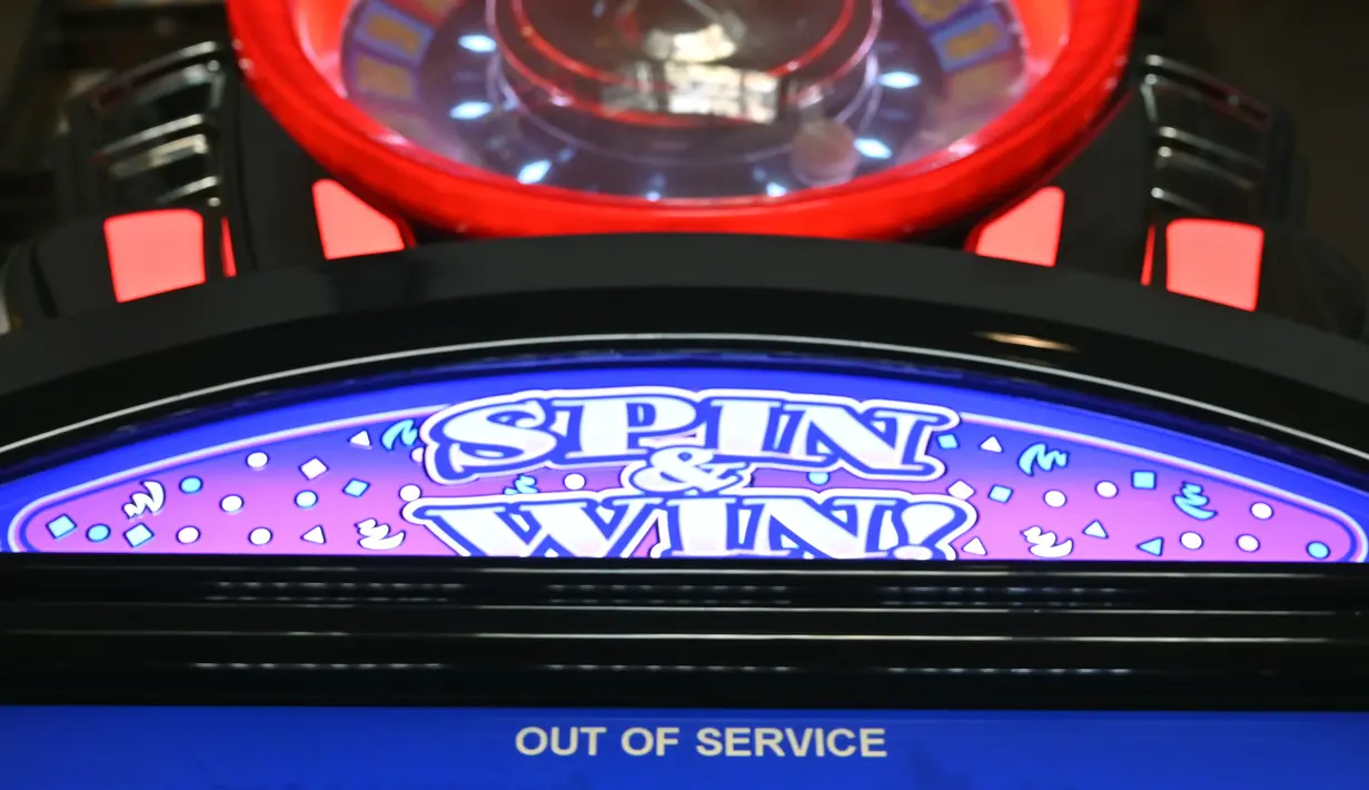 Mesin slot dalam kasino hotel Planet Hollywood menunjukkan pesan 'out of service’ atau 'tidak berfungsi' setelah perintah penutupan kasino akibat virus corona COVID-19 di Las Vegas, Amerika Serikat, Rabu (18/3/2020). Tempat perjudian di Las Vegas ditutup 30 hari ke depan. (AP Photo/David Becker)