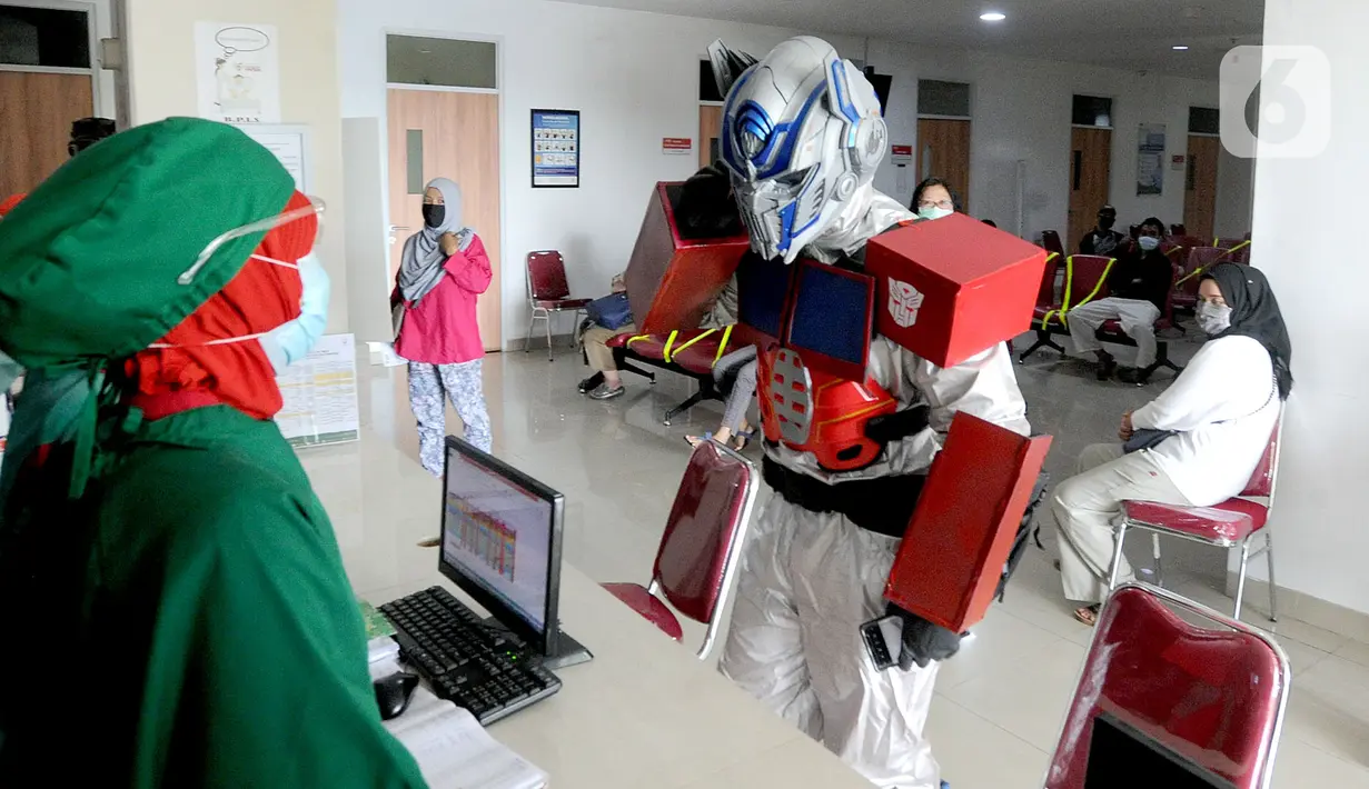 Dokter Rollando Erric Manibuy SpOT mengenakan alat pelindung diri (APD) ala transformer saat berada di RS Vania, Bogor, Jawa Barat, Jumat (22/5/2020). Penggunaan APD unik sejak merebaknya COVID-19 tersebut agar pasien tetap optimis meski sedang dalam pandemi. (merdeka.com/Arie Basuki)
