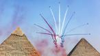 Pesawat K-8E Karakorum dari tim aerobatic "Silver Stars" Angkatan Udara Mesir tampil selama Pyramids Air Show 2022 di atas (kanan ke kiri) Great Pyramid of Khufu, Pyramid of Khafre, dan Pyramid of Menkaure di Giza Pyramids Necropolis, Mesir, 3 Agustus 2022. (Mahmoud Khaled/AFP)