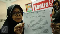 Salah satu keluarga korban pelanggaran HAM menunjukkan surat usai memberikan penyataan di kantor KontraS, Jakarta, (2/3/2016). KontraS beserta keluarga korban pelanggaran HAM masa lalu mendesak pencopotan Jaksa Agung. (Liputan6.com/Helmi Fithriansyah)