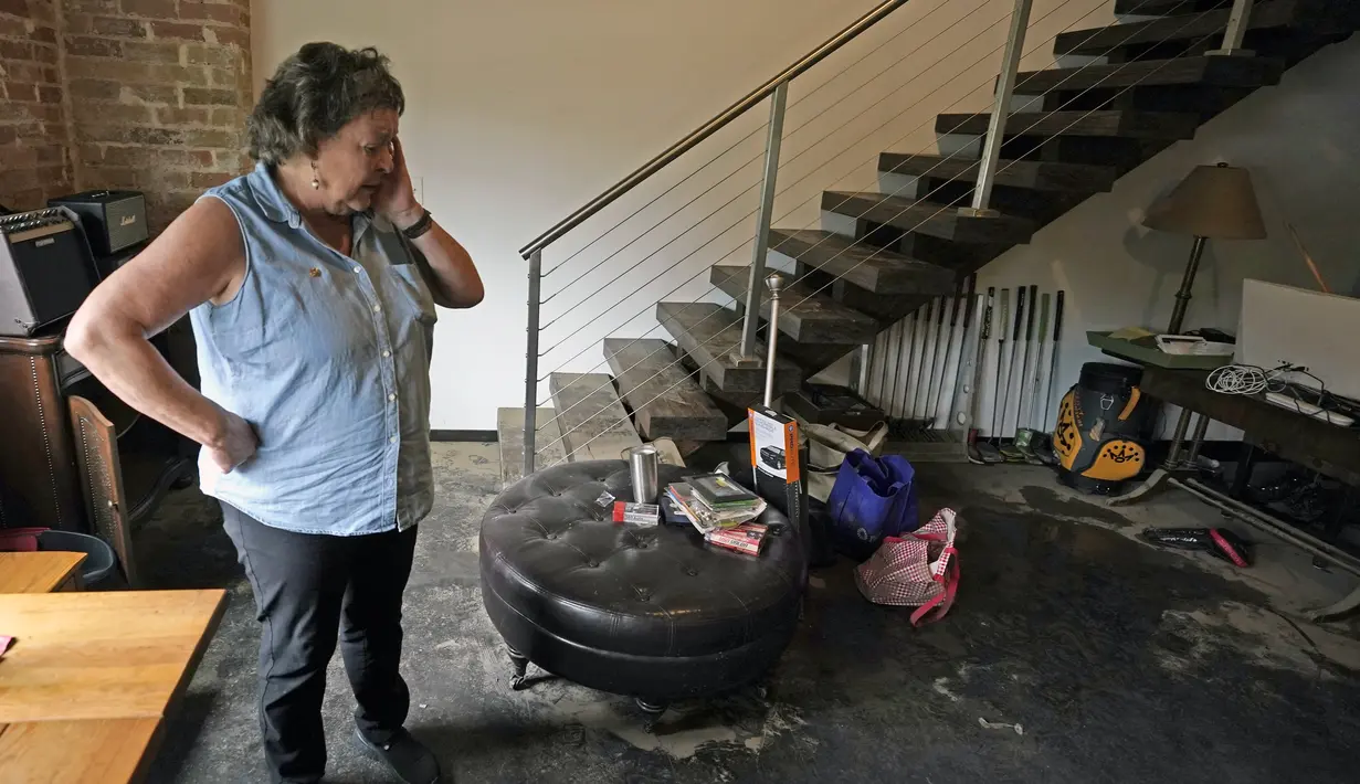 Susan Brosin berhenti sejenak ketika dia berbicara tentang seberapa cepat air masuk dan membanjiri rumahnya di Dallas, Texas, Selasa, 23 Agustus 2022. Warga mulai bersih-bersih sehari setelah hujan deras melanda seluruh wilayah Dallas, Fort Worth, menyebabkan jalan-jalan banjir dan sejumlah kendaraan tenggelam. (AP Photo/LM Otero)