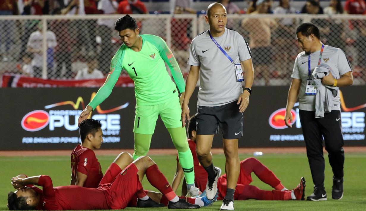 Kiper Timnas Indonesia U-22, Muhammad Riyandi, menghibur rekannya usai dikalahkan Vietnam U-22 pada laga final SEA Games 2019 di Stadion Rizal Memorial, Manila, Selasa (10/12). Indonesia kalah 0-3 dari Vietnam. (Bola.com/M Iqbal Ichsan)