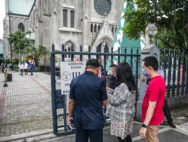 Para Jemaat memperlihatkan bukti pendaftaran untuk mengikuti ibadah di Gereja Katedral, Jakarta, Kamis (24/12/2020). Kapasitas gereja untuk ibadat misa Natal sebanyak 309 kursi, yaitu 20 persen dari kapasitas Gereja Katedral. (Liputan6.com/Faizal Fanani)