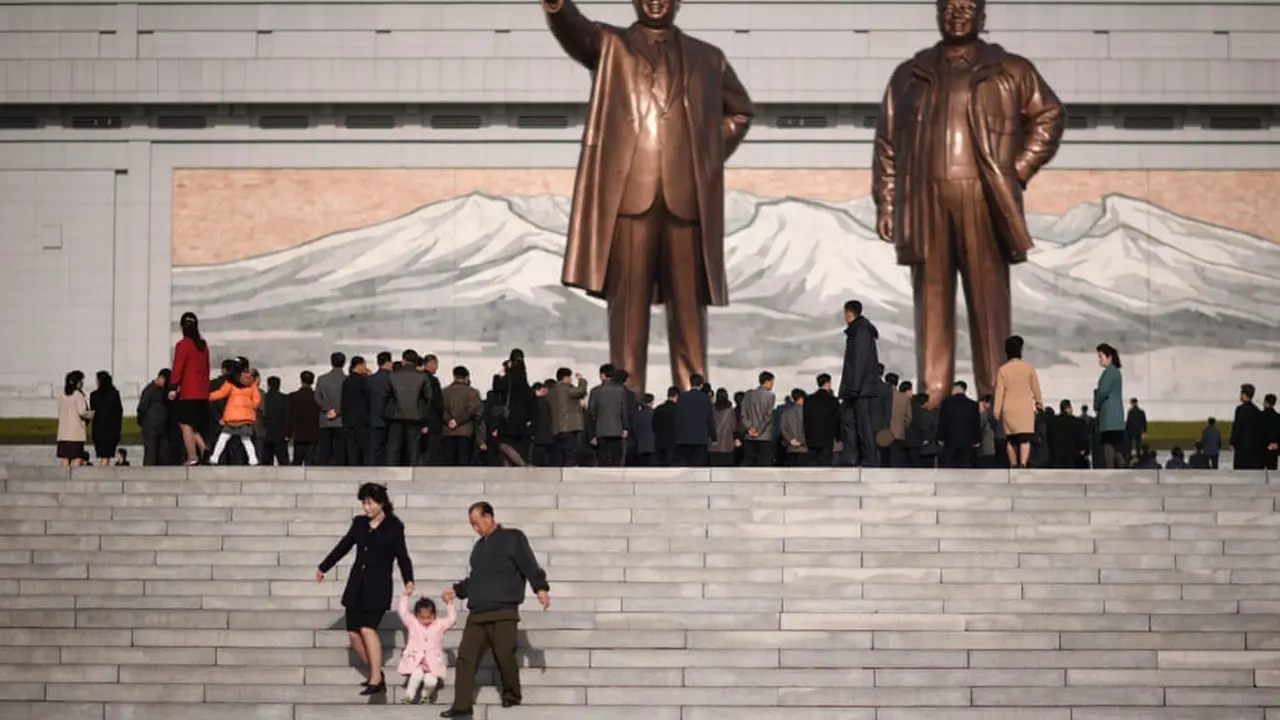 Sebuah keluarga berjalan menuruni tangga setelah memberikan penghormatan di depan dua patung pemimpin Korea Utara sebelumnya (AFP)