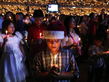 Anak-anak memegang lilin pada perayaan Natal Tiberias Indonesia yang ke-17 di Stadion GBK, Senayan, Jakarta, Sabtu (8/12). Puluhan ribu jemaat dari 14 provinsi menghadiri perayaan natal. (Liputan6.com/Johan Tallo)