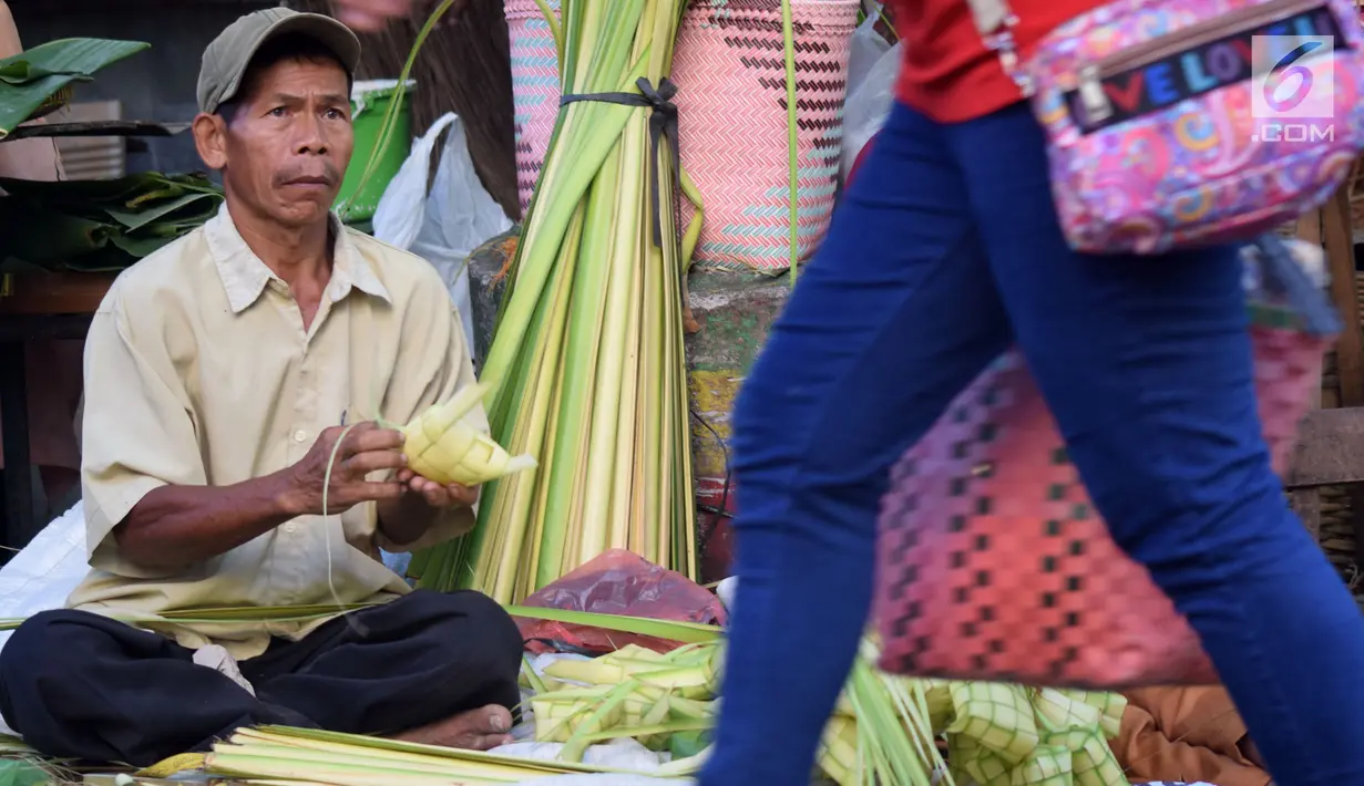 Pedagang merangkai janur menjadi kulit ketupat di Pasar Peterongan Semarang, Jawa Tengah, Kamis (14/6). Penjualan ketupat dan janur mulai marak menjelang lebaran dengan harga Rp 12.000 per sepuluh ketupat. (Liputan6.com/Gholib)