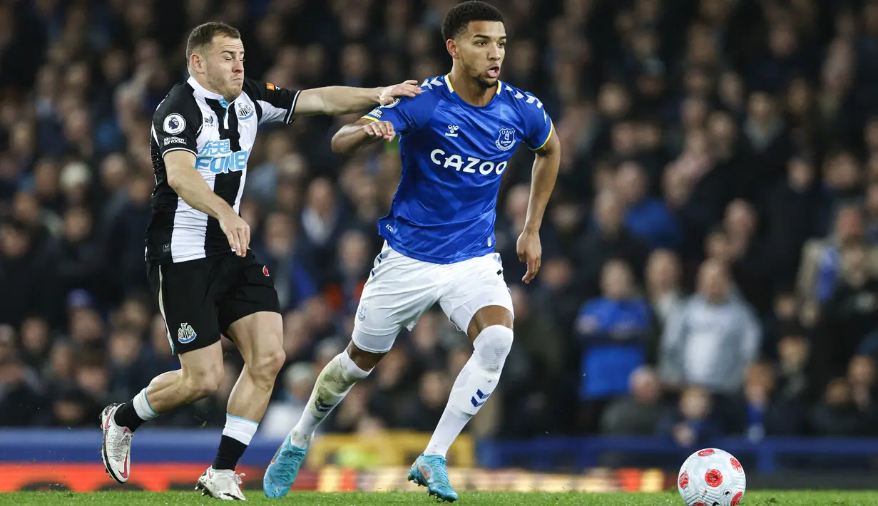 Gelandang Newcastle United Ryan Fraser berebut bola dengan bek Everton Mason Holgate pada lanjutan Liga Inggris di Stadion Goodison Park, Liverpool, Jumat (18/3/2022) dini hari WIB. Bertindak sebagai tuan rumah, Everton menang tipis 1-0.  (Richard Sellers/PA via AP)