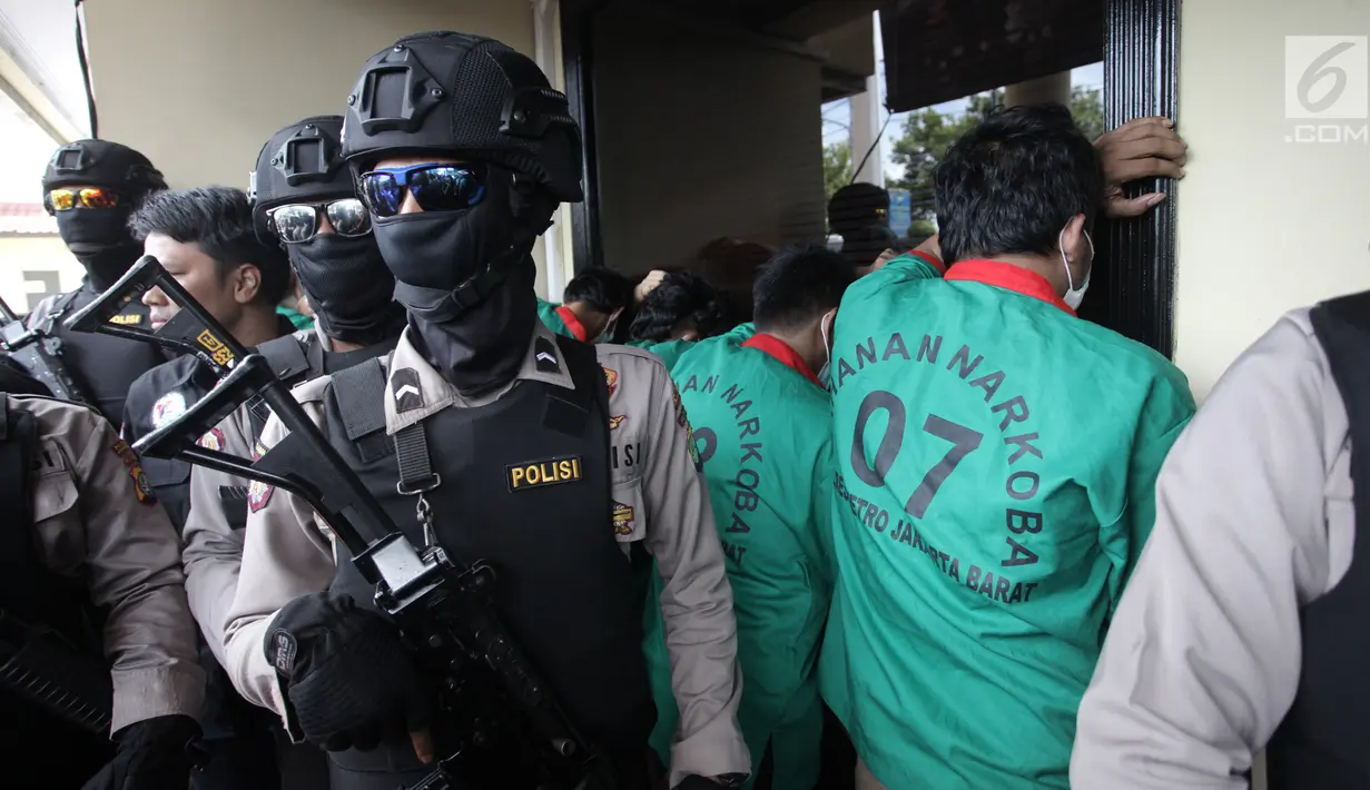 Sejumlah tersangka berbaris menghadap tembok saat ditampilkan dalam rilis pengungkapan 1,3 ton ganja di Polres Jakarta Barat, Kamis (4/1). (Liputan6.com/Arya Manggala)