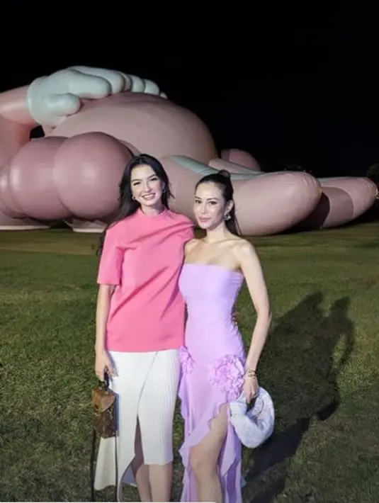 Ia tampil simple dengan oversized shirt pink dan midi pleated skirt berwarna putih [@ralineshah]