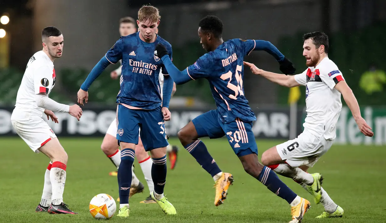Striker Arsenal, Eddie Nketiah, berebut bola dengan gelandang Dundalk, Jordan Flores, pada laga lanjutan Liga Europa 2020/2021 di Aviva Stadium, Jumat (11/12/2020) dini hari WIB. Arsenal menang 4-2 atas Dundalk. (AFP/Paul Faith)