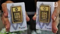 Pramuniaga memperlihatkan emas batangan yang dijual di Galeri 24 Pegadaian, Jakarta, Rabu (27/7/2022). Dalam sepekan, harga emas masih menguat 1,5 persen secara point to point. Dalam sebulan, harga emas sudah amblas 5,5 persen sementara dalam setahun merosot 4,3 persen. (Liputan6.com/Angga Yuniar)