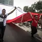 Peserta membentangkan bendera merah putih raksasa pada Karnaval Cinta Budaya NKRI di MH Thamrin, Jakarta, Minggu (20/11). Karnaval ini bertujuan merawat dan menyiram perdamaian, toleransi, harmoni dan persaudaraan kebangsaan. (Liputan6.com/Faizal Fanani)