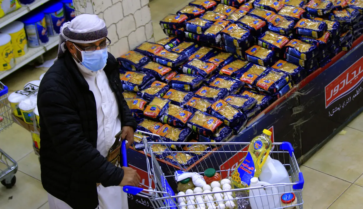 Seorang pria berbelanja bahan makanan dan persediaan saat mereka mempersiapkan diri seminggu menjelang bulan suci Ramadan di supermarket di ibu kota Yaman, Sanaa, Selasa (6/4/2021). (AFP Photo/Mohammed Huwais)