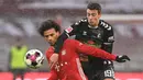 Gelandang Bayern Munich, Leroy Sane (kiri) berebut bola dengan striker Freiburg, Janik Haberer dalam laga lanjutan Liga Jerman 2020/21 pekan ke-16 di Allianz Arena, Minggu (17/1/2021). Bayern Munich menang 2-1 atas Freiburg. (AFP/Christof Stache/Pool)
