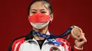 Lifter putri Indonesia Windy Cantika Aisah menunjukkan medali perunggu Olimpiade Tokyo 2020 cabang angkat besi nomor 49 kg di Tokyo International Forum, Sabtu (24/7/2021). Windy Cantika mempersembahkan medali pertama bagi Indonesia yakni perunggu dengan total angkatan 194 Kg. (Vincenzo PINTO/AFP)