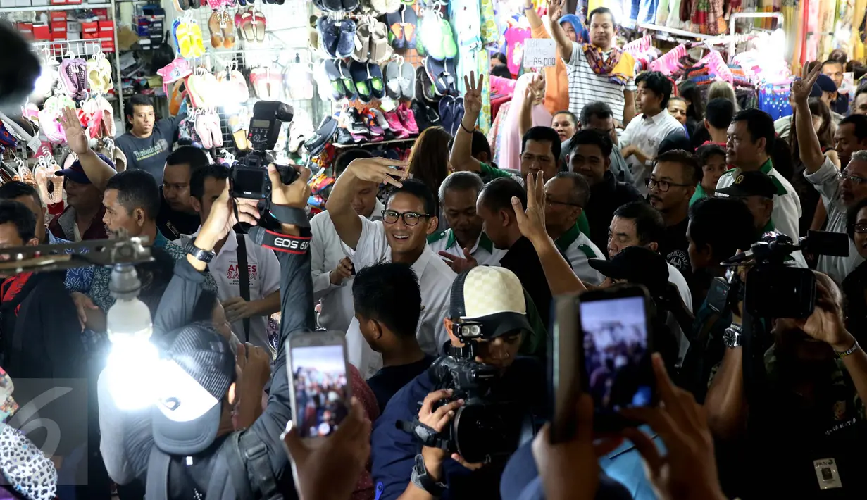 Cawagub DKI Jakarta, Sandiaga Uno berpose dengan tiga jari saat menyambangi ITC Mangga Dua, Jakarta Utara, Kamis (3/11). Di ITC tersebut, Sandiaga berkeliling untuk menyapa dan berdialog dengan pedagang serta pengunjung. (Liputan6.com/Gempur M Surya)