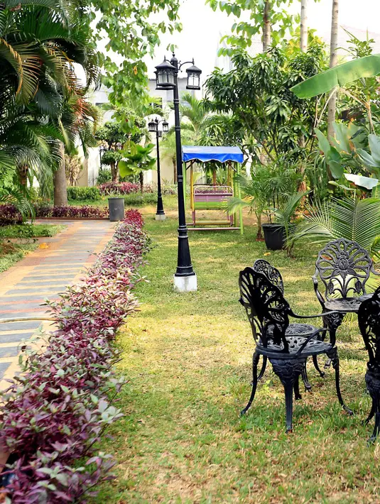 Rumah berlantai dua yang didiami pasangan ini memiliki arsitektur modern minimalis. Di sisi rumah terbentang taman yang luas. Bereneka tumbuhan bunga dan tanaman keras di halaman rumah mereka. (Andy Masela/Bintang.com)