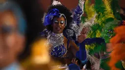 Anggota karnaval Uruguay, Comparsa, menari mengikuti irama musik selama parade karnaval Llamadas di Montevideo, Kamis (7/2). Karnaval terbesar di Uruguay ini menampilkan kelompok penari seksi dan musik tradisional selama dua hari. (PABLO PORCIUNCULA/AFP)
