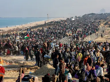 Orang-orang berjalan di sepanjang Jalan Al-Rashid di wilayah pesisir untuk menyeberangi koridor Netzarim dari Jalur Gaza selatan ke utara pada 27 Januari 2025. (Omar AL-QATTAA/AFP)