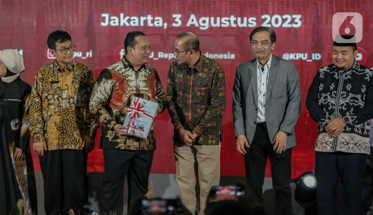 Anggota I BPK Nyoman Adhi Suryadnyana (ketiga kiri) membawa Laporan Hasil Pemeriksaan BPK Atas Laporan Keuangan KPU Tahun 2022 untuk diserahkan kepada Ketua KPU Hasyim Asy'ari (ketiga kanan). (Liputan6.com/Faizal Fanani)