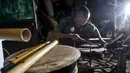 Pembuat rebana tradisional, Fajar Siddiq, yang kehilangan pekerjaan karena pandemi Covid-19, bekerja di rumahnya di Lambaro, Provinsi Aceh, Senin (22/2/2021). Usaha produksi berbagai jenis alat musik tradisional Aceh berupa rapai, serune kale dan seruling mulai langka. (CHAIDEER MAHYUDDIN / AFP)