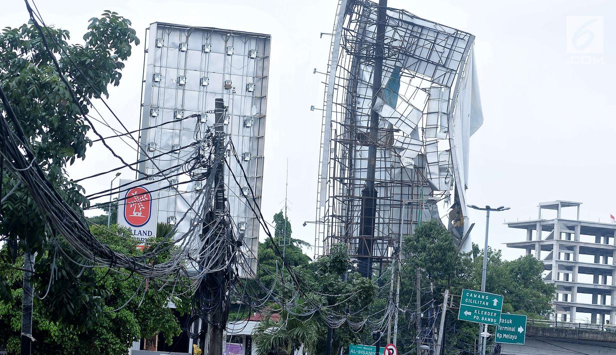Kondisi papan reklame yang hampir roboh yang berada di kawasan Terminal Kampung Melayu, Jakarta (2/10). Hujan deras disertai angin kencang yang mengguyur Ibu Kota kemarin membuat papan reklame ini hampir roboh.(Liputan6.com/Helmi Afandi)