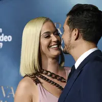 Penyanyi Katy Perry tertawa dengan pacarnya Orlando Bloom saat menghadiri pemutaran perdana untuk serial televisi "Carnival Row" di Los Angeles, California, AS (21/8/2019). Katy Perry dan Orlando Bloom tampil mesra dengan saling mencium di acara tersebut. (AP Photo/Chris Pizzello)