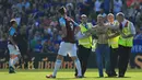 Petugas keamanan menangkap suporter yang trun ke dalam lapangan saat laga Leicester City melawan West Ham Unitd di King Power Stadium, Leicester, (5/5/2018).  West Ham menang 2-0. (AFP/Lindsey Parnaby)