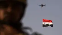 Sebuah drone mengibarkan bendera nasional Irak saat perayaan keberhasilan menyingkirkan militan ISIS dari Kota Tua Mosul, Minggu (9/7). Irak memulai pertempuran merebut Mosul pada Oktober lalu dengan dukungan dari koalisi pimpinan AS. (FADEL SENNA/AFP)