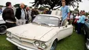 Seorang pengunjung berpose di dekat pintu mobil 1964 Chevrolet Corvair 500 selama Concours d'lemon di Seaside, California, AS, (20/8). Para pengunjung dibuat terpana dengan Mobil antik yang dipamerkan dan ingin memilikinya. (Reuters/Michael Fiala)