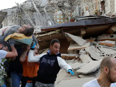Seorang pria dengan keadan hidup dibawa usai tertimbun reruntuhan akibat gempa dahsyat menghantam kota Amatrice, Italia tengah, (24/8). Gempa menyebabkan kerusakan besar dan getarannya membuat panik penduduk yang sedang tertidur. (REUTERS/Remo Casilli) 