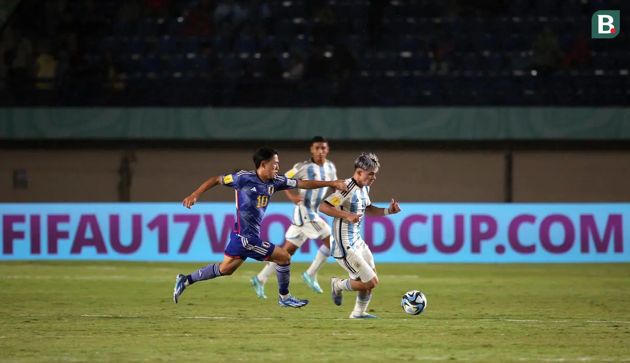<p>Pemain Timnas Argentina U-17, Santiago Lopez (kanan) menggiring bola dikejar pemain Timnas Jepang U-17, Ryonosuke Sato pada laga kedua Grup D Piala Dunia U-17 2023 di Stadion Si Jalak Harupat, Kabupaten Bandung, Selasa (14/11/2023). (Bola.com/Ikhwan Yanuar)</p>