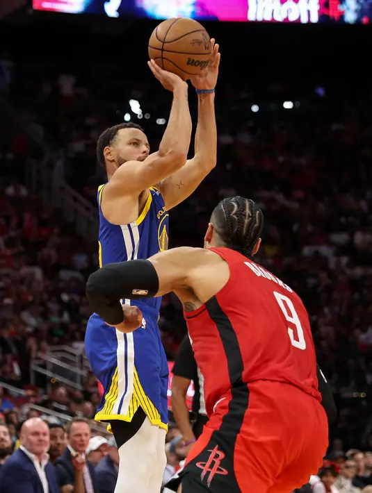Pemain Golden State Warrirors, Stephen Curry (kiri) melakukan three poin shoot setelah mengecoh pemain Houston Rockets, Dillon Brooks pada laga lanjutan NBA 2023/2024 di Toyota Center, Houston, Texas, 29 Oktober 2023 waktu setempat. (AFP/Getty Images/Tim Warner)