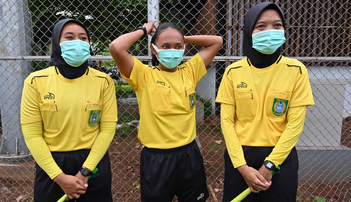 Wasit wanita (tengah) dan dua asistennya bersiap sebelum memimpin pertandingan internal Timnas sepakbola putri Indonesia proyeksi SEA Games 2021 Vietnam dalam rangka pembukaan pemusatan latihan (TC) di Lapangan D Kompleks Gelora Bung Karno, Senayan, Jakarta, Senin (8/3/2021). (AFP/Adek Berry)