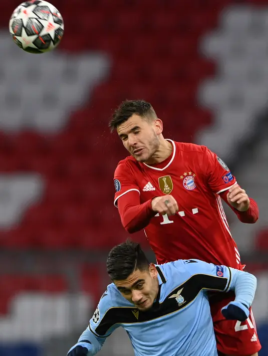 Gelandang Lazio Andreas Pereira dan bek Bayern Munchen Lucas Hernandez melompat untuk menyundul bola pada leg kedua babak 16 besar Liga Champions di Allianz Arena, Kamis dinihari WIB (18/3/2021). Bayern Munchen menang 2-1 atas Lazio dan maju ke perempatfinal dengan agregat 6-2. (CHRISTOF STACHE/AFP)