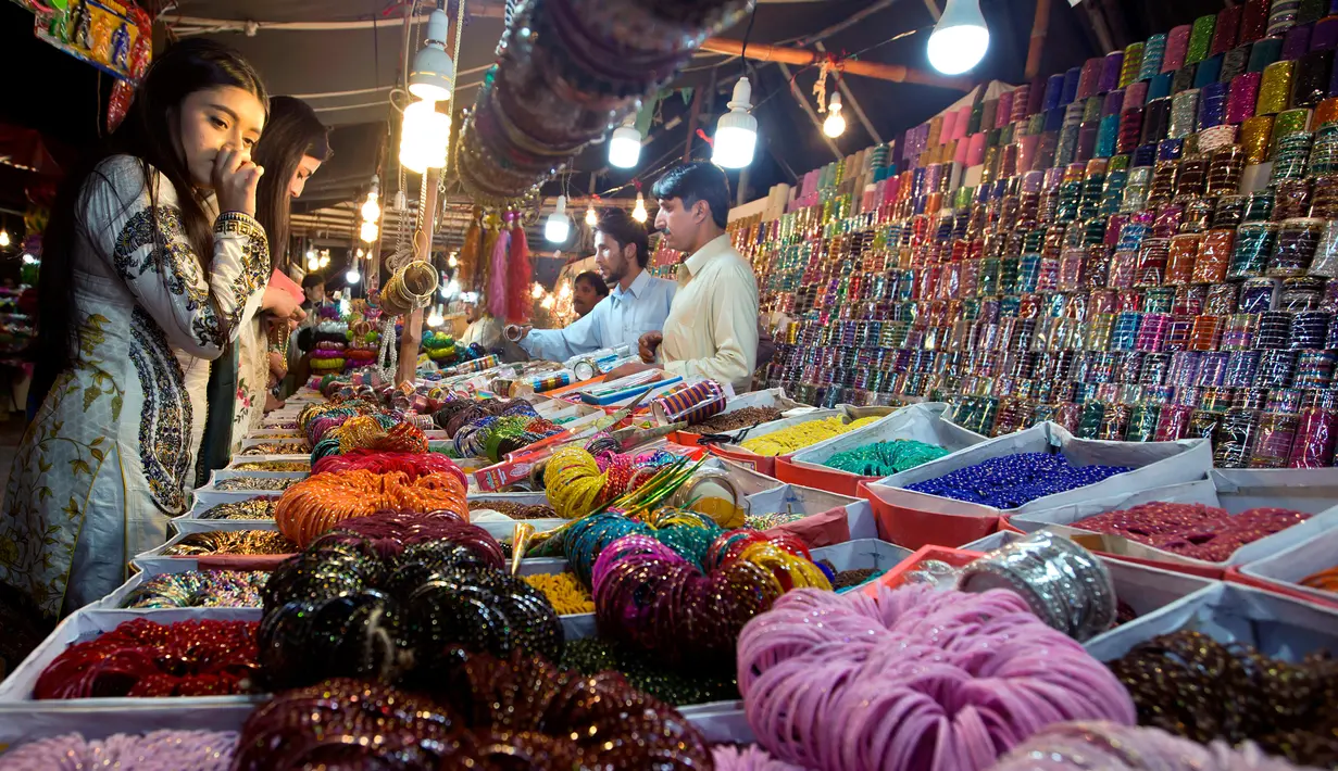 Seorang gadis muda Pakistan memilih perhiasan di sebuah pasar di Lahore, Selasa (12/6). Umat muslim di berbagai penjuru dunia sedang mempersiapkan untuk merayakan Idul Fitri, yang menandai berakhirnya bulan suci Ramadan. (AP/Anjum Naveed)