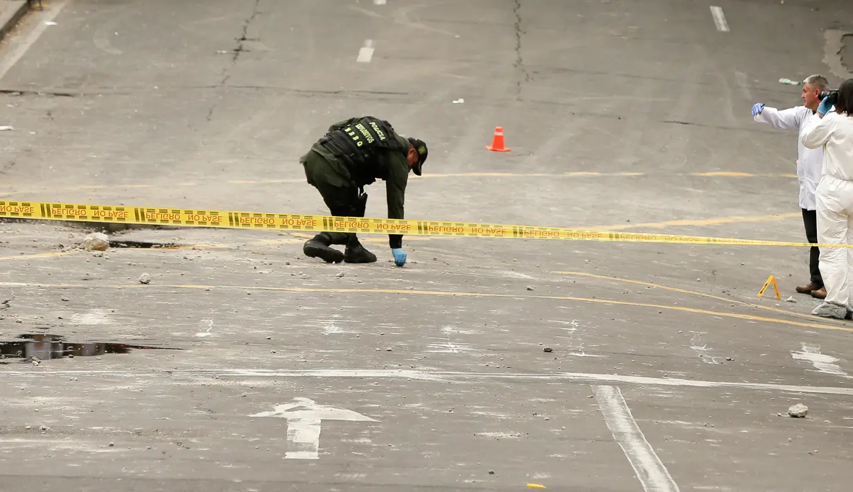 Polisi Kolombia dan ahli forensik memeriksa lokasi ledakan di dekat arena adu banteng Plaza Santamaria di pusat kota Bogota, Minggu (19/2). Hingga saat ini belum ada informasi yang detail terkait ledakan di arena adu banteng itu (AP Photo/Ricardo Mazalan)