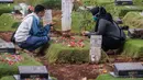 Umat Muslim berdoa di makam keluarga saat melakukan ziarah di Tempat Pemakaman Umum (TPU) Pondok Ranggon, Jakarta, Minggu (04/04/21). Meskipun di tengah pandemi Covid-19 warga tetap melakukan tradisi ziarah kubur. menjelang bulan Ramadan. (Liputan6.com/Faizal Fanani)