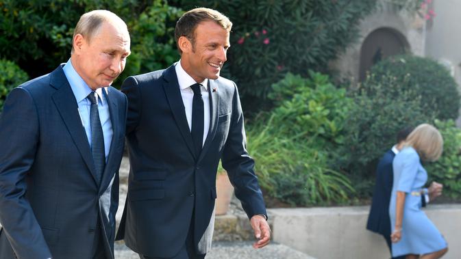 Presiden Prancis Emmanuel Macron (kanan) menyambut Presiden Rusia Vladimir Putin di Benteng Bregancon, Bormes-les-Mimosas, Prancis, Senin (19/8/2019). Pertemuan Putin dan Macron untuk membahas krisis dunia. (Gerard JULIEN/POOL/AFP)