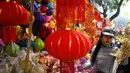 Seorang wanita berbelanja dekorasi Tahun Baru Imlek atau perayaan Tet di sebuah pasar pusat Kota Tua Hanoi, Senin (28/1). Setiap perayaan imlek, warga Vietnam akan menghias rumah dengan berbagai dekorasi berwarna merah. (Manan VATSYAYANA/AFP)