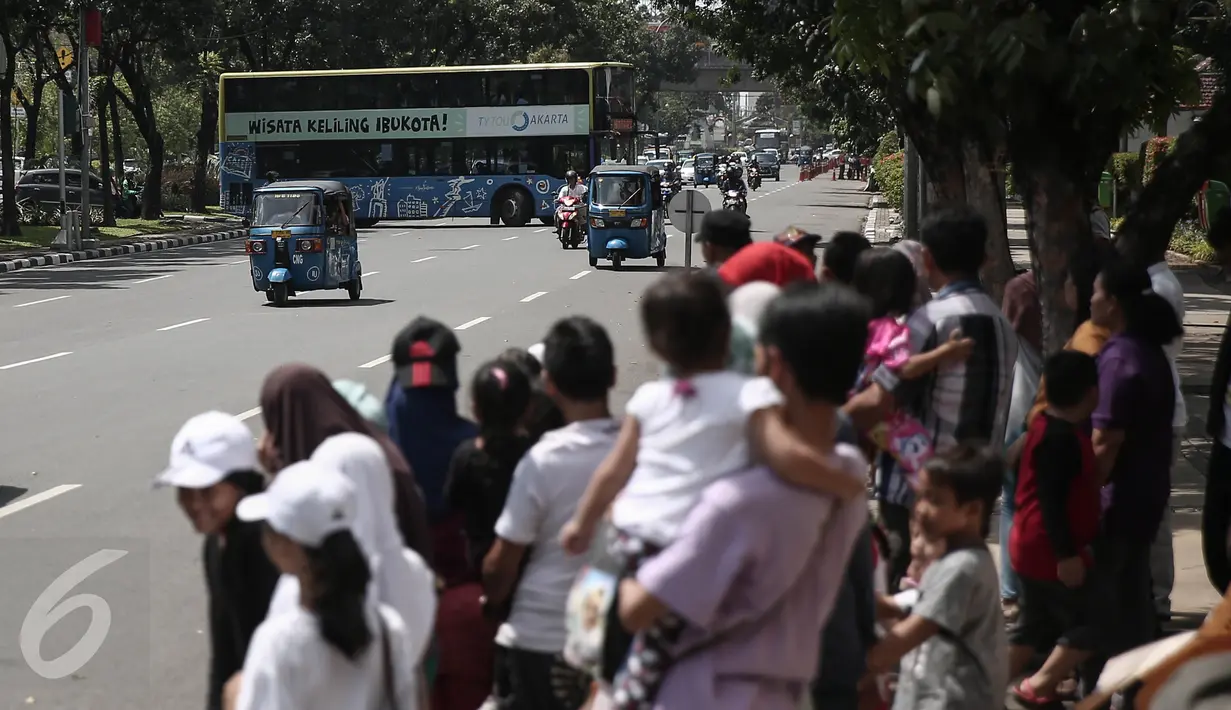Penumpang menunggu bus tingkat wisata di Jalan Merdeka Selatan, Jakarta, Minggu (15/5). Gubernur DKI, Basuki TJahaja Purnama atau Ahok berencana menambah 25 unit bus tingkat guna memudahkan sarana transportasi masyarakat.  (Liputan6.com/Faizal Fanani)
