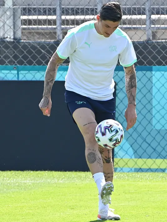 Gelandang timnas Swiss, Steven Zuber melakukan pemanasan dengan bola selama sesi latihan di pusat olahraga Tre Fontane di Roma Selasa (15/6/2021). Timnas Italia akan meladeni Swiss di Stadio Olimpico, Roma di laga kedua Grup A Euro 2020 pada Kamis, 17 Juni 2021 dini hari WIB. (ANDREAS SOLARO/AFP)