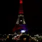 Pengunjung memandangi Menara Eiffel yang disoroti lampu pelangi, Paris, Senin (13/6/2016). Menara yang terkenal dengan romantisme itu memberikan penghormatan untuk korban penembakan brutal di klub malam gay di Orlando, Florida AS. (Thomas SAMSON/AFP)