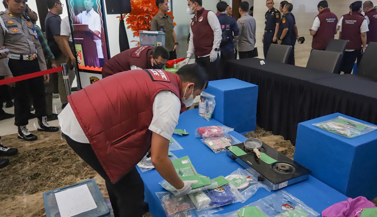 Kemudian, ada ketamine seberat 1.077,72 gram, kokain 33,12 gram, MDMA 21,09 gram, ganja 36,92 gram, dan happy five 3,5 butir. Tampak dalam foto, personel Dirtpidnarkoba Bareskrim Polri menata barang bukti pengungkapan peredaran narkoba jelang gelaran Djakarta Warehouse Project (DWP) 2025 di Bali pada 12–14 Desember 2025 lalu di gedung Bareskrim Mabes Polri, Jakarta, Senin (22/12/2025). (merdeka.com/Arie Basuki)