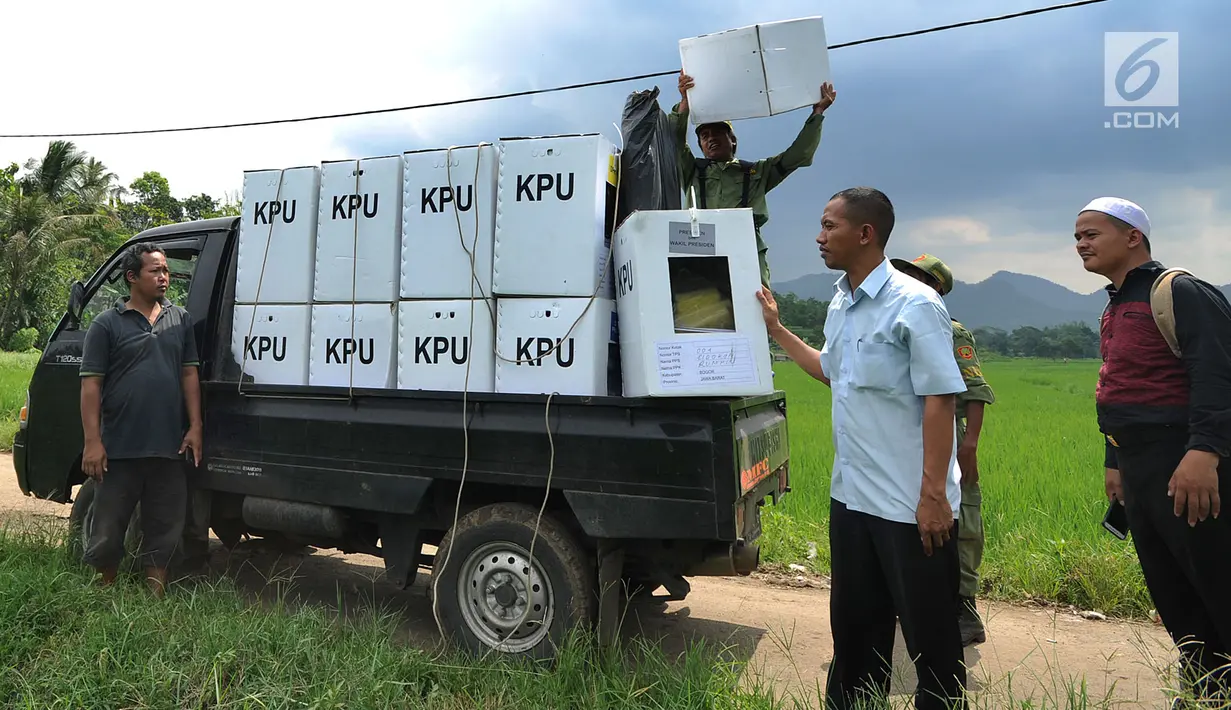 Petugas KPPS menurunkan kotak suara menuju TPS di desa Cidokom, Bogor, Selasa (16/4). Dalam hitungan jam, lebih dari 200 juta penduduk Indonesia akan segera menyalurkan hak pilihnya dengan mendatangi TPS yang tersebar di 34 Provinsi yang ada di Tanah Air. (Merdeka.com/Arie Basuki)