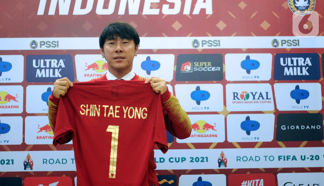 Shin Tae-Yong menunjukkan kaus bertuliskan namanya saat perkenalan pelatih baru Timnas Indonesia di Ruang VVIP Stadion Pakansari, Kab Bogor, Jawa Barat, Sabtu (28/12/2019). Shin Tae-Yong resmi menandatangani kontrak sebagai pelatih Timnas Indonesia selama 4 tahun. (Liputan6.com/Helmi Fithriansyah)